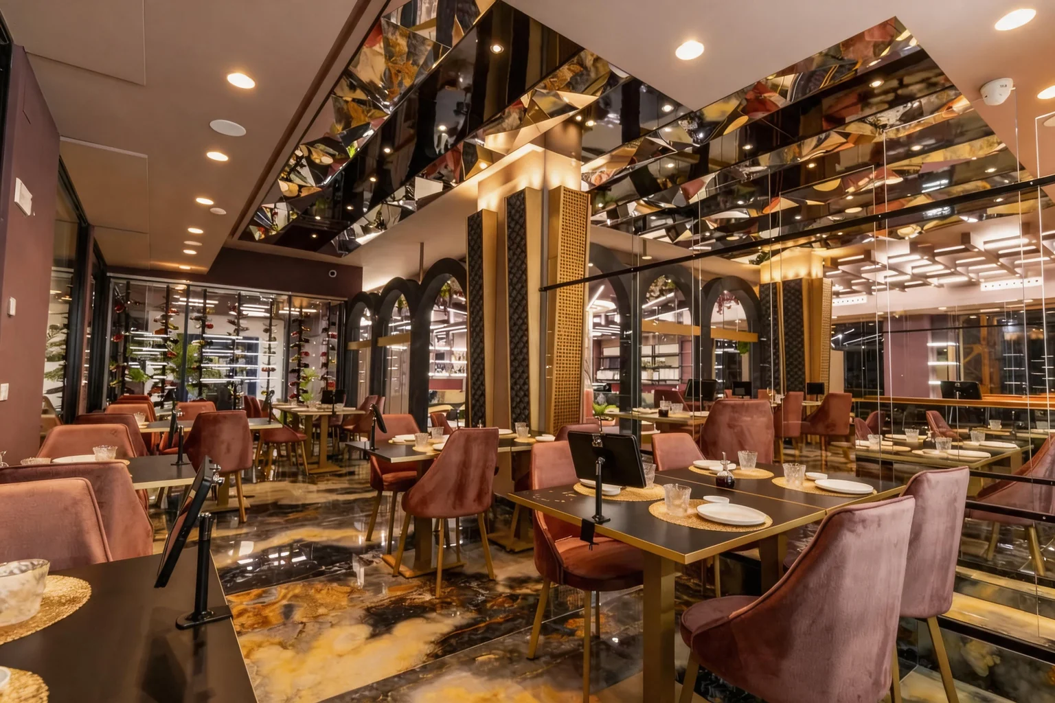 The dining room with pink velvet chairs, a mirrored ceiling, marble floor and the wine wall.